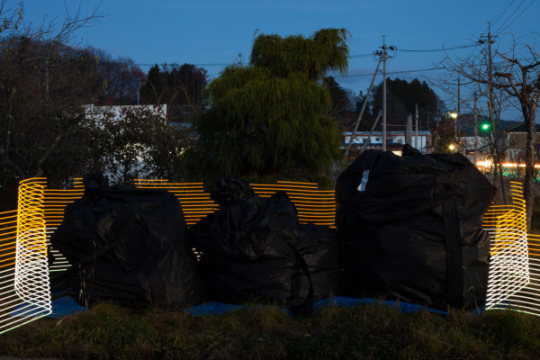 A special light painting tool reveals radiation levels around abandoned bags of contaminated waste outside Mr Hiroshi Kanno's former home in Kusano, Iitate, Fukushima. Here we see radiation levels between 0.38uSv/h and 0.51uSv/h, with yellow showing spots elevated above the government decontamination target of 0.23 uSv/h. Greenpeace/Greg McNevin