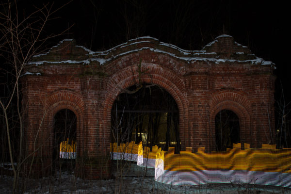 A special light painting tool displays radiation levels in real-time at a gateway to a former church in the centre of Starye Bobovichi (Старые Бобовичи), Russia. Here white light shows contamination levels up to 0.23uSv/h, while orange highlights elevated levels – from 0.50uSv/h to 0.85uSv/h. 30 years after the 1986 Chernobyl nuclear disaster, the schoolyard still contains areas of elevated radiation levels. No digital manipulation is involved in the image. Greenpeace/Greg McNevin