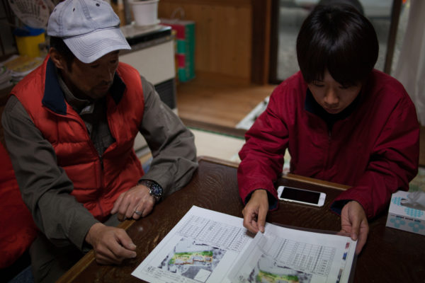 151116 - At his former home in Ryozen, Oguni, Mr Saiki Sugano explains to a Greenpeace radiation protection advisor how the decontamination effort at his home has been far from sufficient, and that it has since been recontaminated from the untouched surrounding land and forest. Greenpeace/Greg McNevin